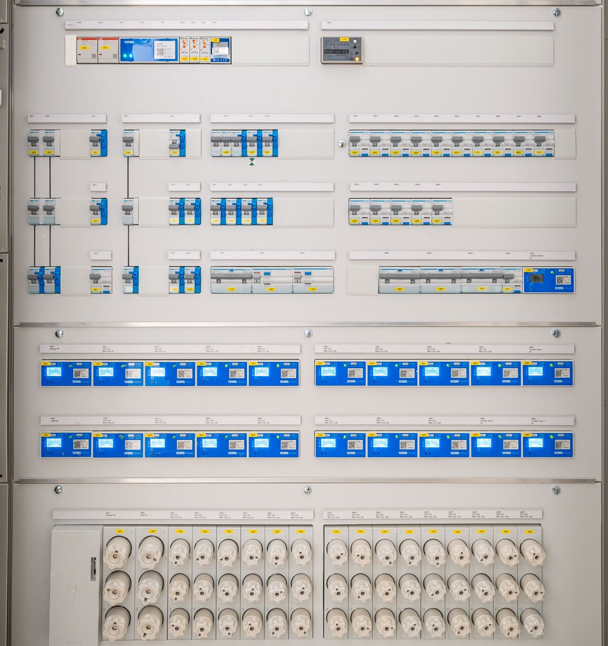 Quadro de distribuição grande, com disjuntores alinhados, circuitos identificados um a um e medidores digitais